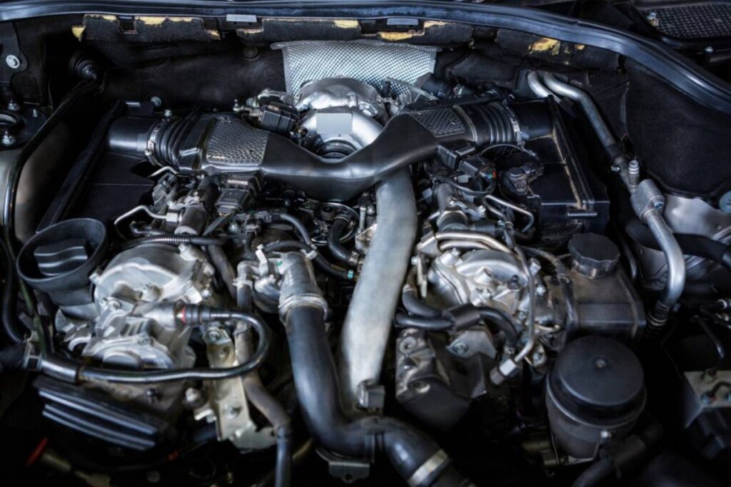 Close-up of a powerful car engine showcasing intricate components, hoses, and metal parts in a well-maintained engine bay.