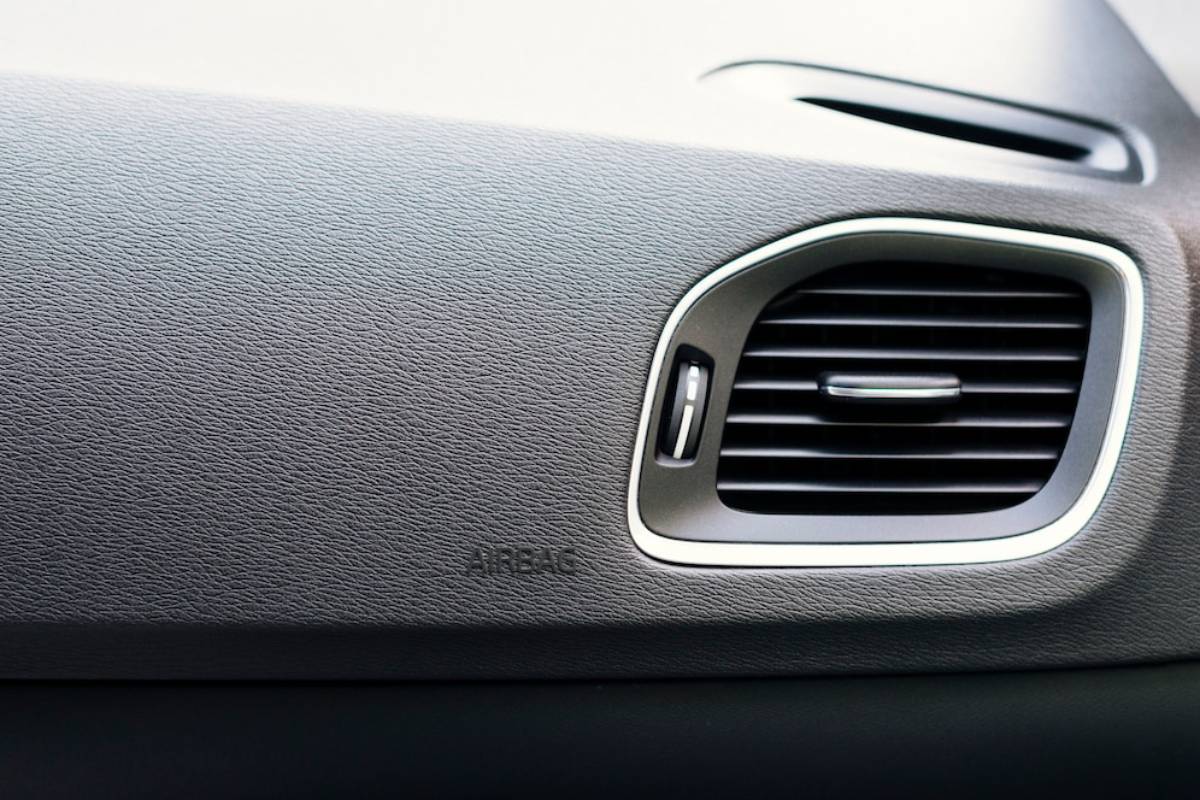 Close-up of a car dashboard showing an air vent and highlighting textured material and metallic accents.