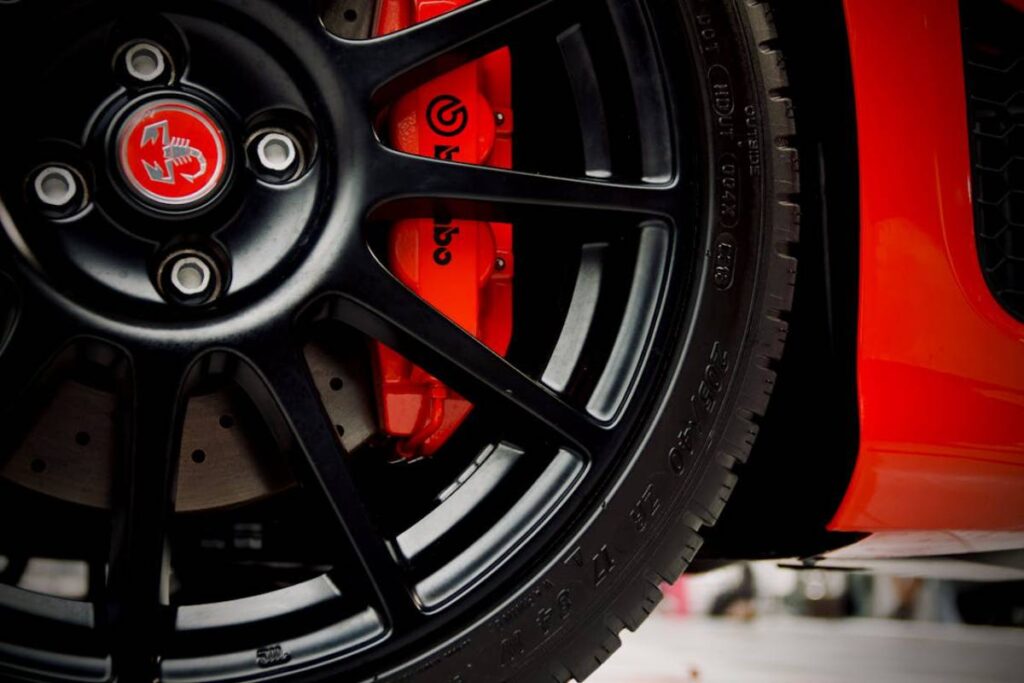 Close-up of a black alloy wheel featuring a red brake caliper.
