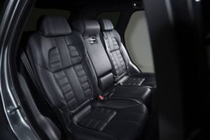 Three luxurious black leather seats in a modern car interior, showcasing sleek design and premium cushioning.