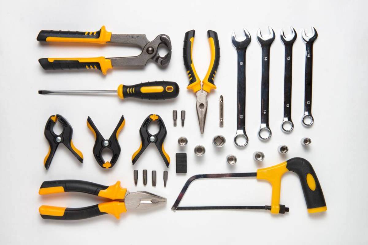  Assorted hand tools including screwdrivers, wrenches, pliers, and a hacksaw on a white background.